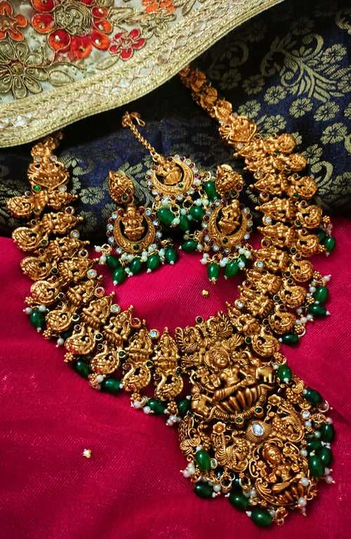 N03082_Grand Haram classic matte gold polished temple jewelry style crafted design gold plated necklace set embellished with green stones .