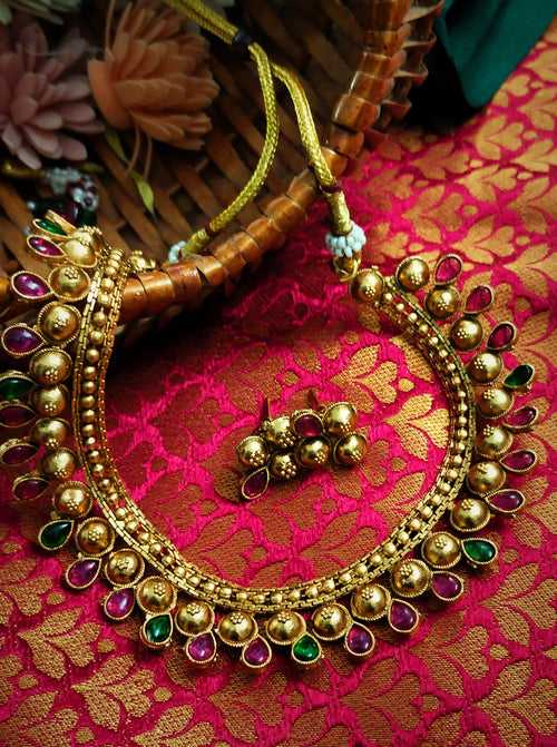 N03016_Classic matte gold polished temple jewelry style crafted design gold plated necklace set embellished with ruby and green stones .