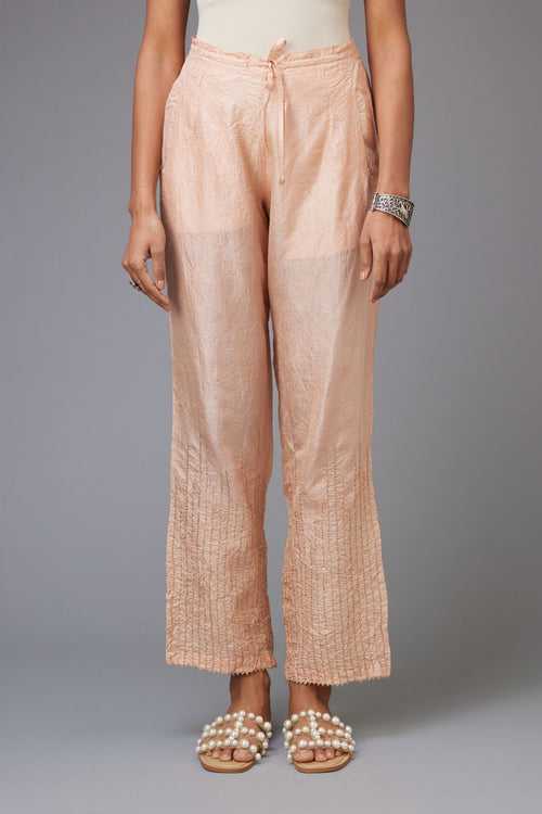 Pink hand crushed silk straight pants with golden sequin lines from calf to hem, highlighted with gota lace at edges.