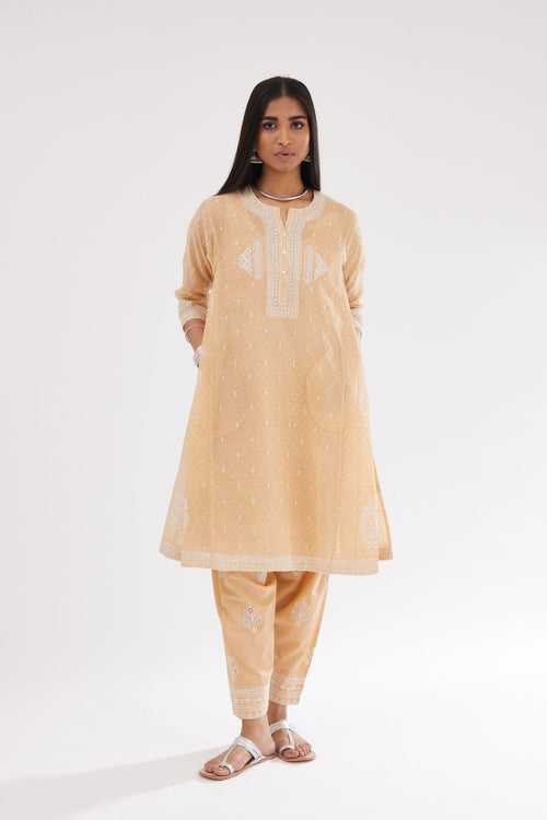 Peach cotton chanderi hand block printed short kalidar phiran style kurta with button placket neckline and dori and silk thraed embroidery all over.