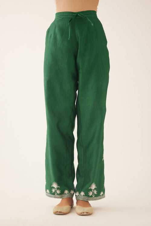 Green silk chanderi straight pants with off white silk thread embroidery at hem.