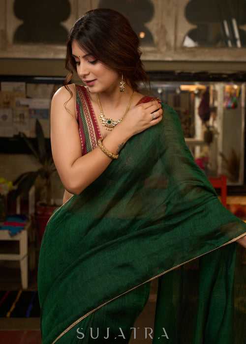 Trendy bottle green cotton saree highlighted with golden lace