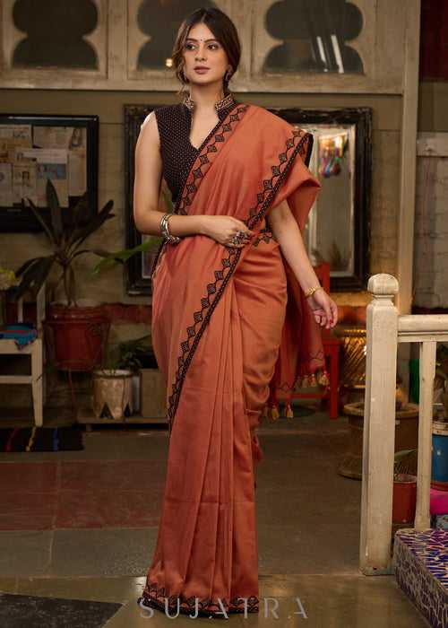 Graceful rust cotton plain saree highlighted with overall ajrakh applique border