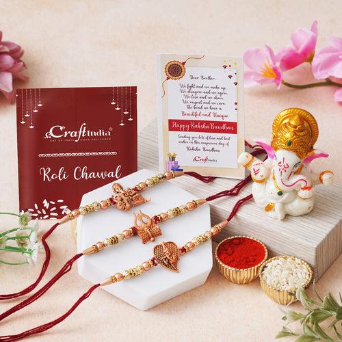 Set of 3 Red & Golden Trishul with Damru, Lord Ganesha, & Lord Krishna Playing Flute Religious Rakhis with Lord Ganesha Idol, Roli Chawal Pack, Greeting Card