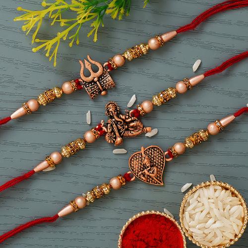 Set of 3 Red & Golden Trishul with Damru, Lord Ganesha, & Lord Krishna Playing Flute Religious Rakhis with Lord Ganesha Idol, Roli Chawal Pack, Greeting Card