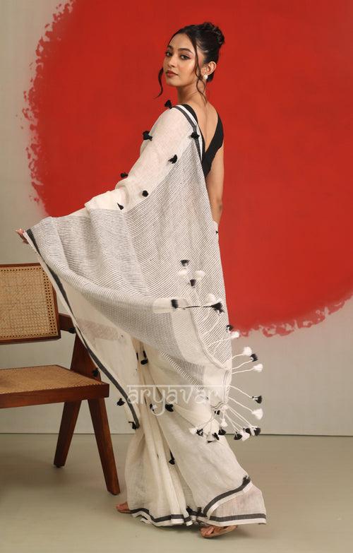 A striking White Linen Saree With woven in Pom Poms