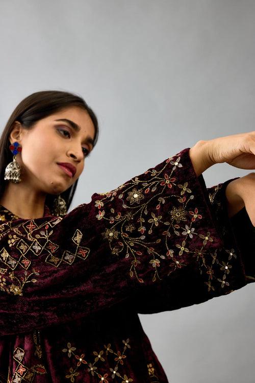 Maroon silk velvet shirt with all-over hand block print, highlighted with sequins, beads and zari work, paired with maroon silk velvet hand block printed straight pants with embroidered boota at sides, highlighted with sequins, beads and zari work.