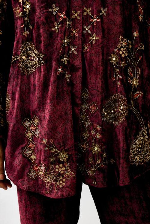 Maroon silk velvet shirt with all-over hand block print, highlighted with sequins, beads and zari work, paired with maroon silk velvet hand block printed straight pants with embroidered boota at sides, highlighted with sequins, beads and zari work.