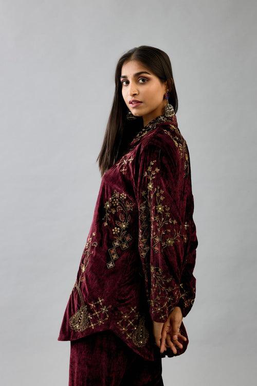 Maroon silk velvet shirt with all-over hand block print, highlighted with sequins, beads and zari work, paired with maroon silk velvet hand block printed straight pants with embroidered boota at sides, highlighted with sequins, beads and zari work.