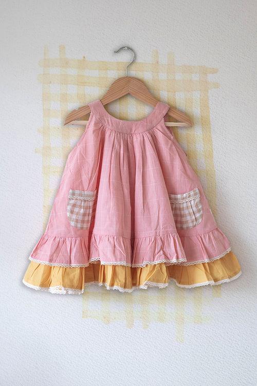 ‘Pocketful of sunsets' sleeveless dress in peach pink with yellow frill in handwoven cotton