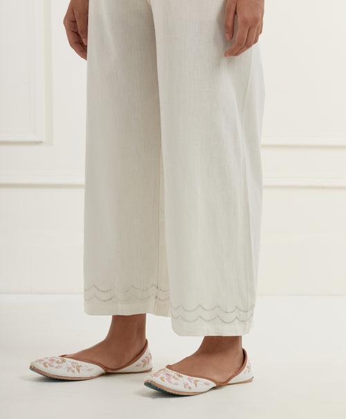 Off white chanderi cotton flax pants in a straight  fit with silver pittan embroidery at the hem